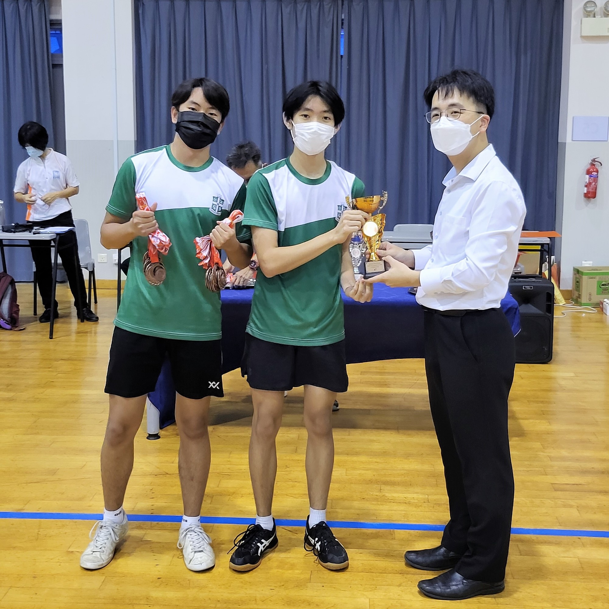 20220425-NSGBadminton-Jonathan and Leo receiving 4th place medals and 4th place trophy from Principal KCPSS.jpeg